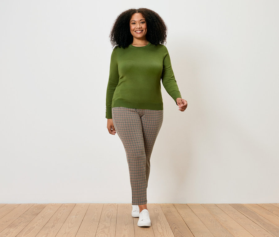 Nő sétál, világoszöld finomkötött pulóvert visel.