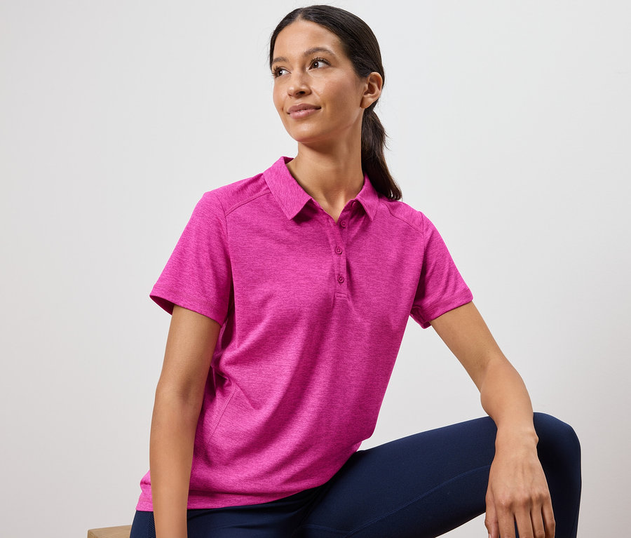 Nő rózsaszín pólót és sötétkék leggingst visel.