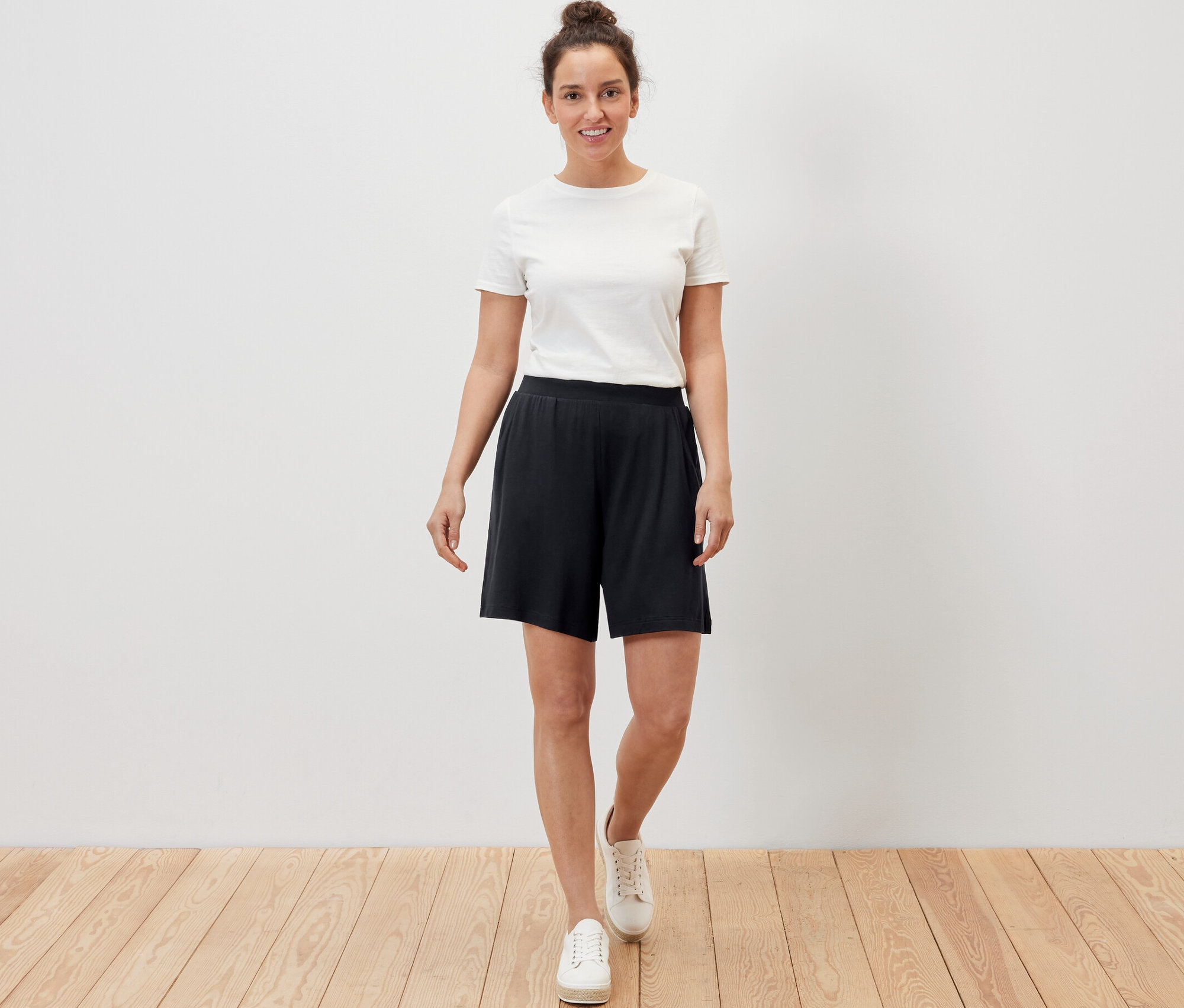 Nő visel fekete jersey rövidnadrágot.