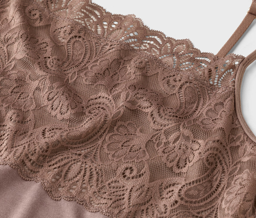 Közeli kép egy bézs csipkés spagetti pántos felsőről.