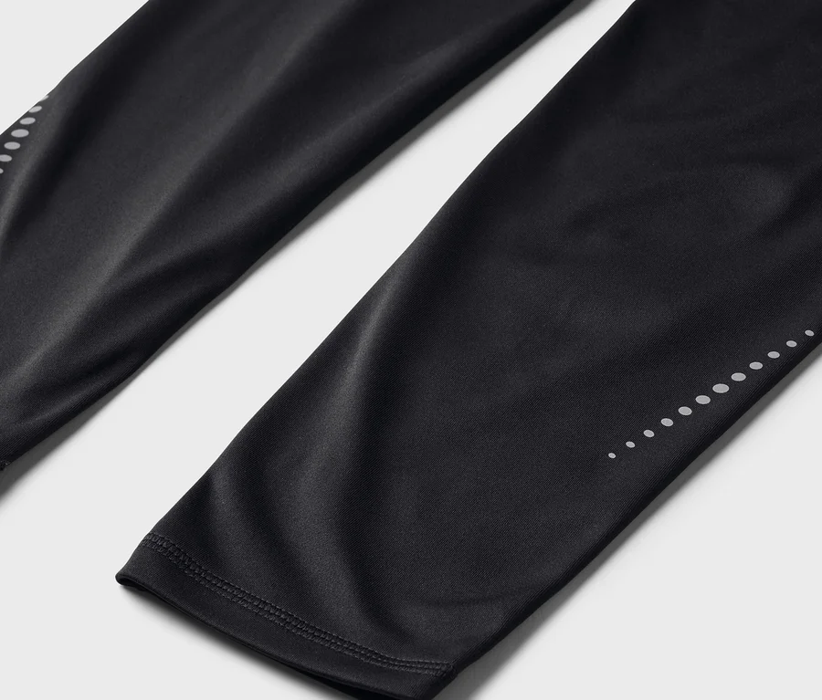 Fekete leggings közeli képe, a lábszár alsó részén fényvisszaverő pontokkal.
