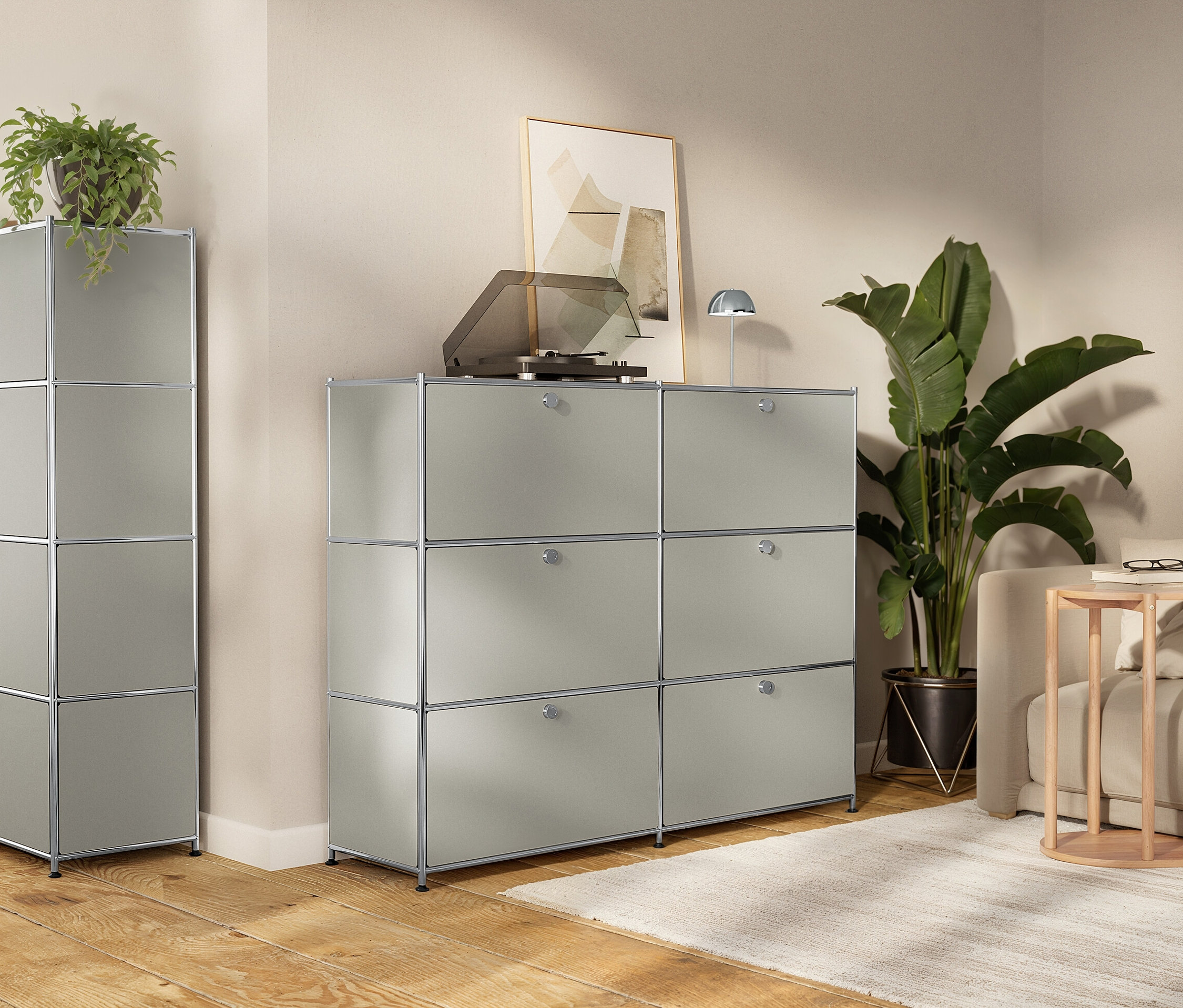 Nappali moduláris, szürke tárolószekrényekkel, lemezjátszóval, szobanövényekkel és kanapéval.