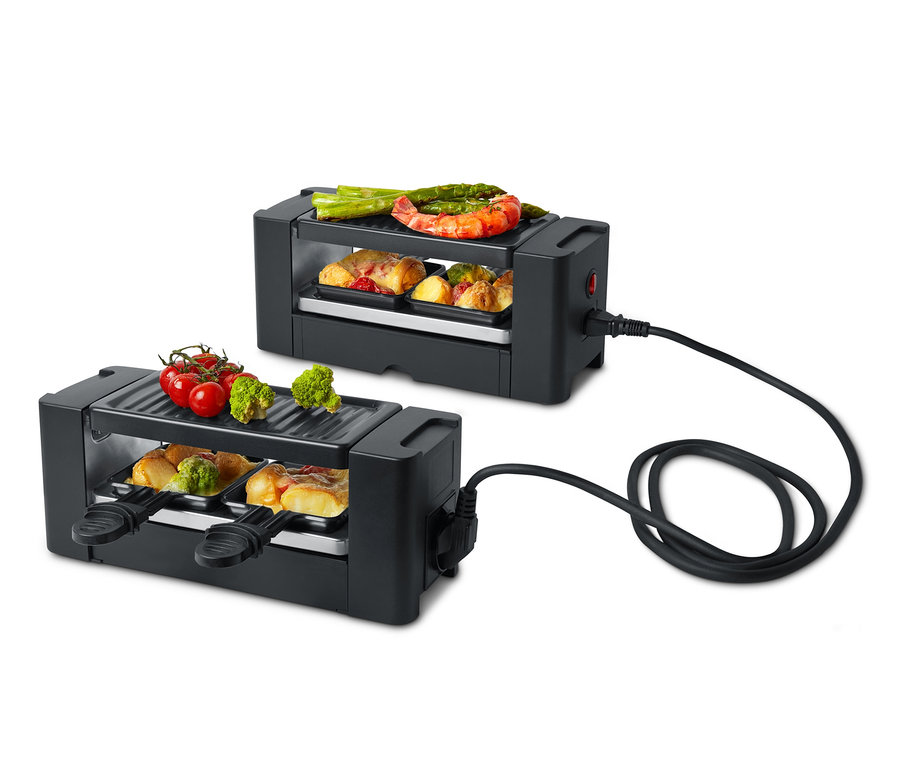 Két fekete kétszemélyes raclette grill különféle ételekkel a tetején és belül.