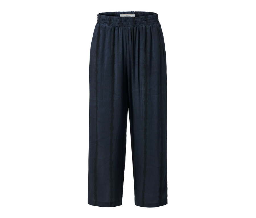 Egy sötétkék, batikolt női 3/4-es bőszárú nadrág.