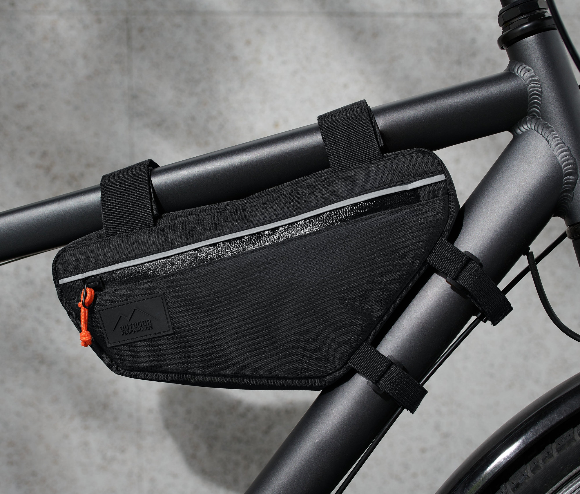 Egy fekete kerékpáros váztáska van rögzítve a kerékpár vázához.
