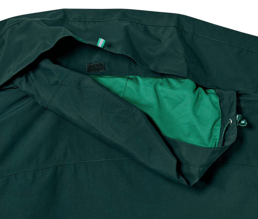 Egy sötétzöld férfi funkcionális túradzseki részlete.