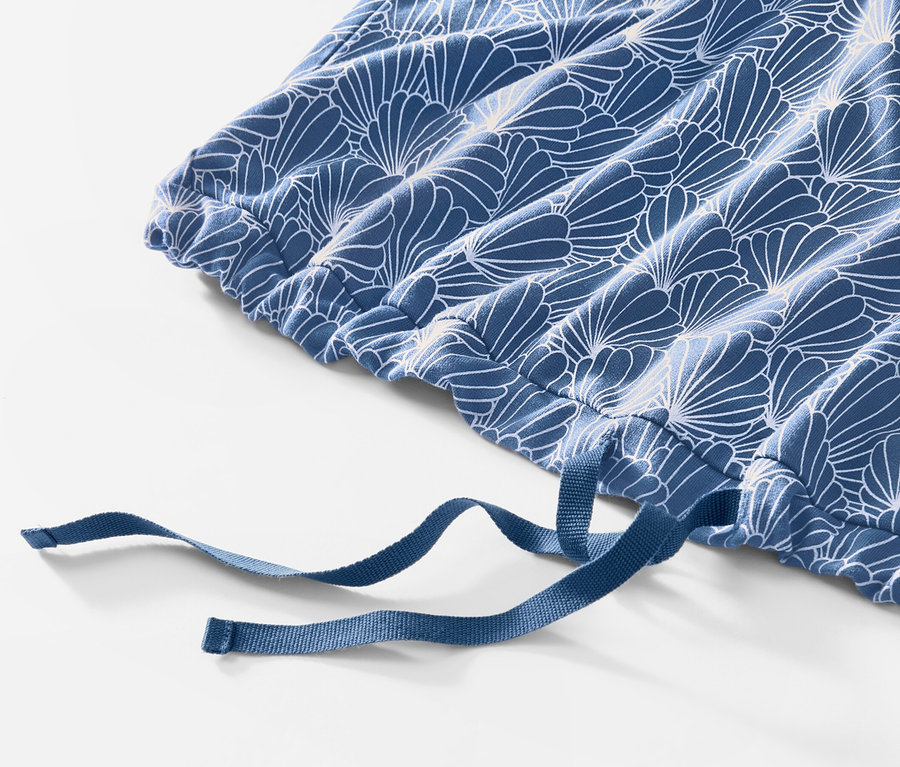 Egy kék-fehér virágmintás, húzózsinóros női pizsama leggings részlete.