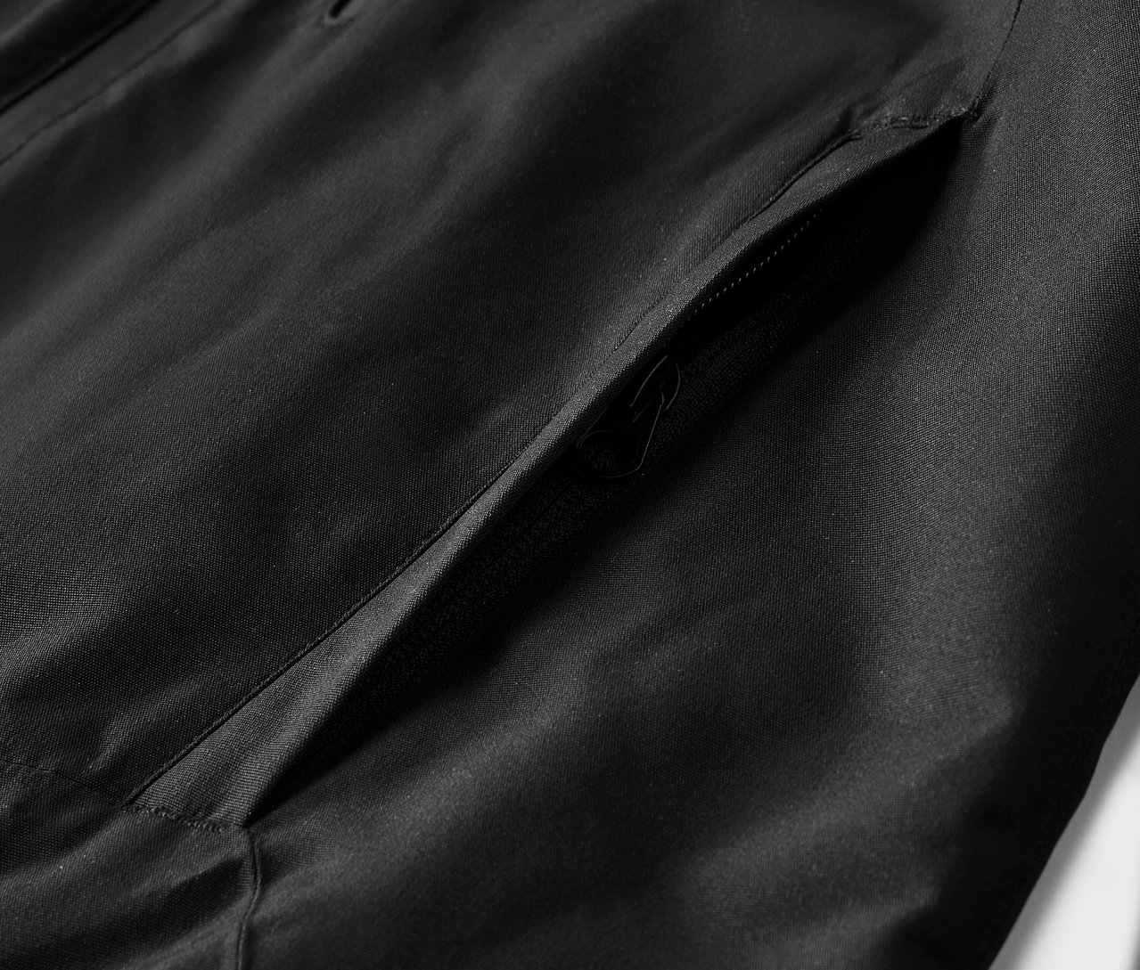 Egy fekete kabát részlete zsebbel.