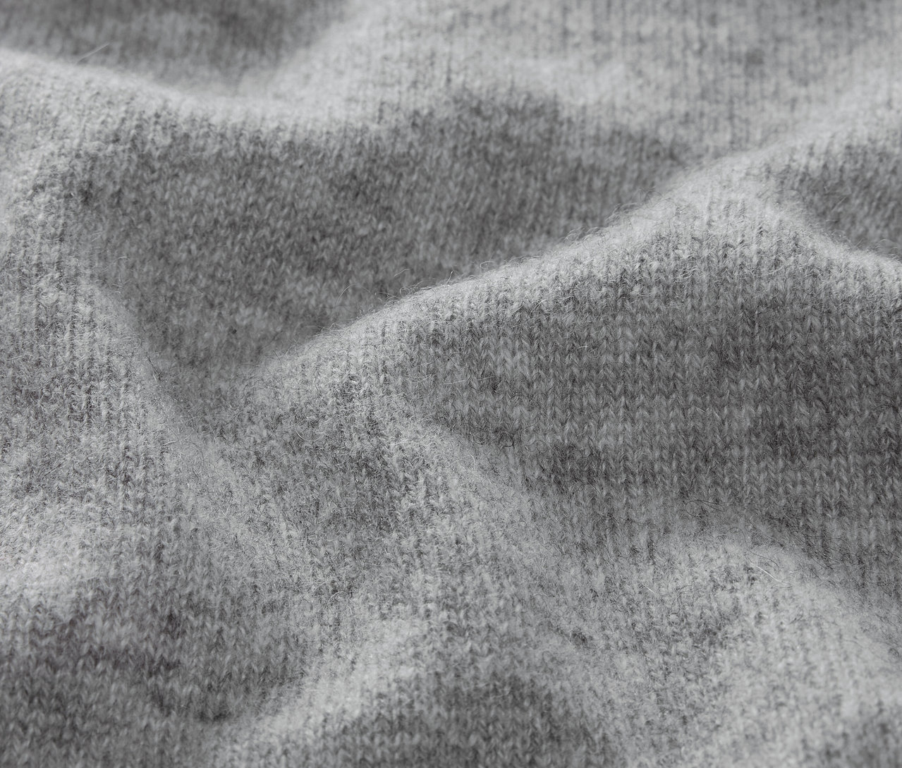 Egy szürke kötött anyag textúrájának közeli felvétele.