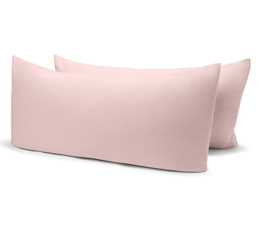 Két világos rózsaszín párna fekszik egymás mellett fehér háttéren.