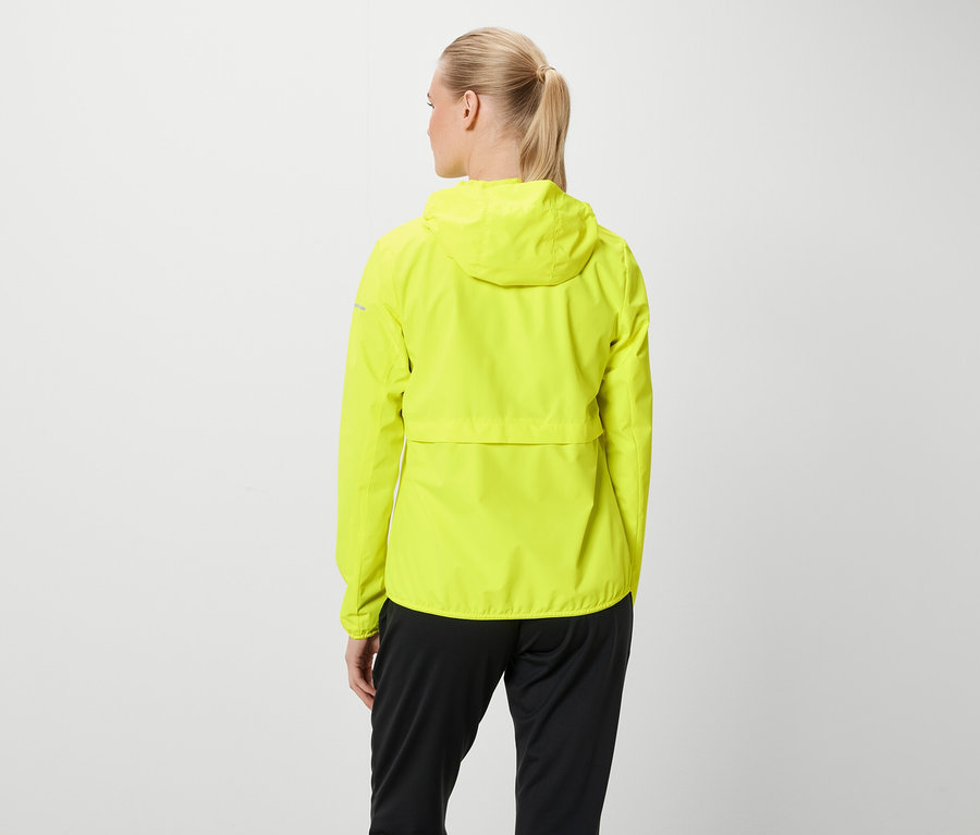 Hátulról látható egy szőke hajú, lófarokba kötött nő, aki neon sárga kapucnis kabátot és fekete nadrágot visel.
