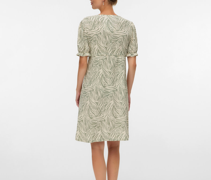 Hátulról látható nő zebracsíkos mintázatú térdig érő ruhában és szandálban.