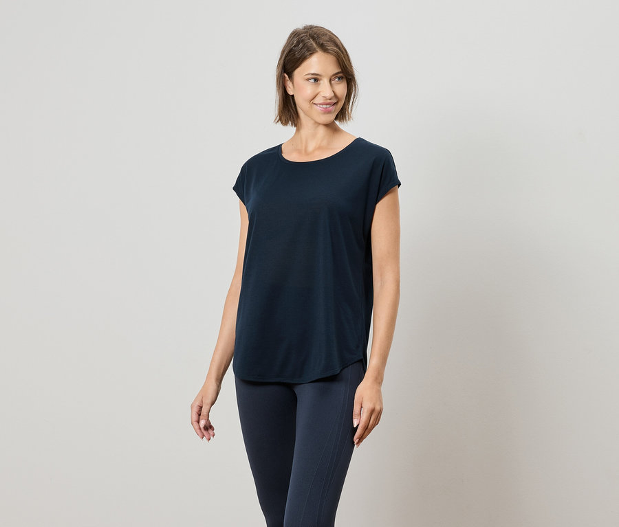 Nő visel tengerészkék pólót és tengerészkék leggingset.