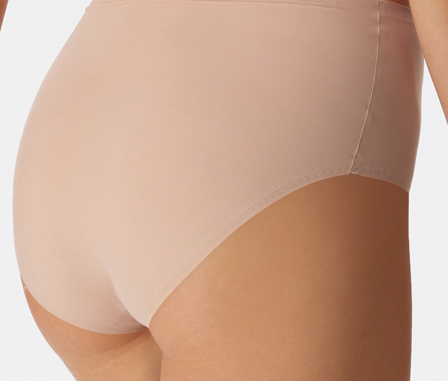 Közeli kép egy testszínű alsóneműt viselő nő hátuljáról.