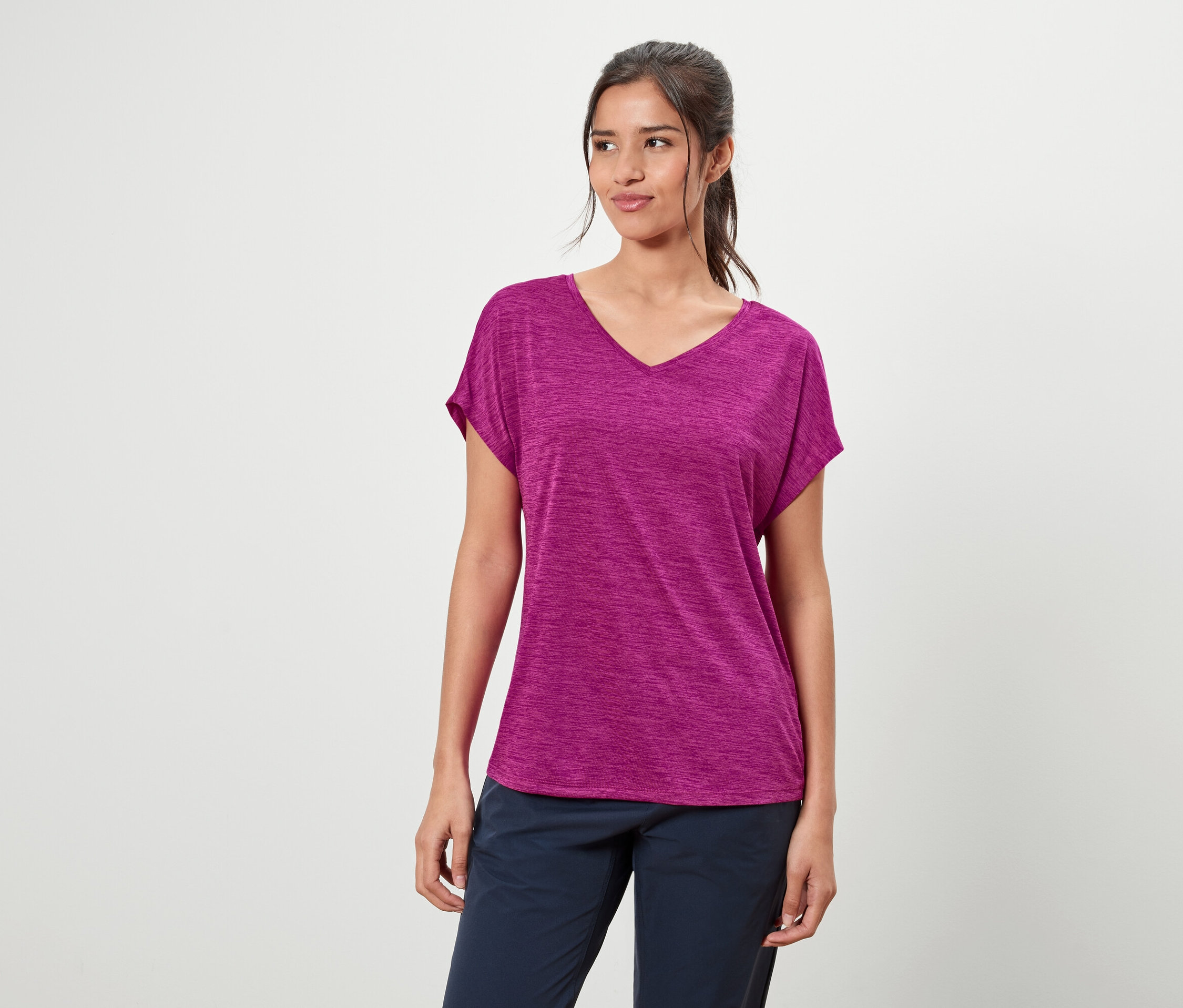 Nő lila pólót és kék nadrágot visel.