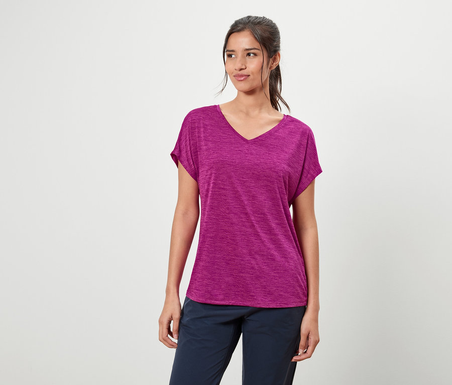 Nő lila pólót és kék nadrágot visel.