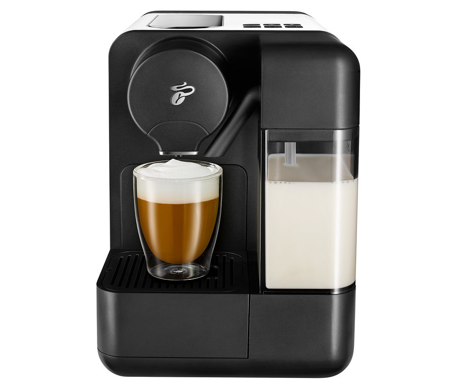 Fekete kávéfőző fehér Cafissimo tejjel és egy kávéval teli pohárral.