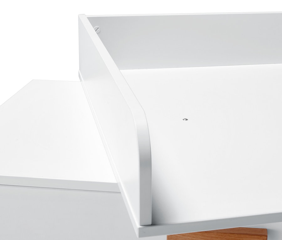 Egy fehér pelenkázó komód részlete.