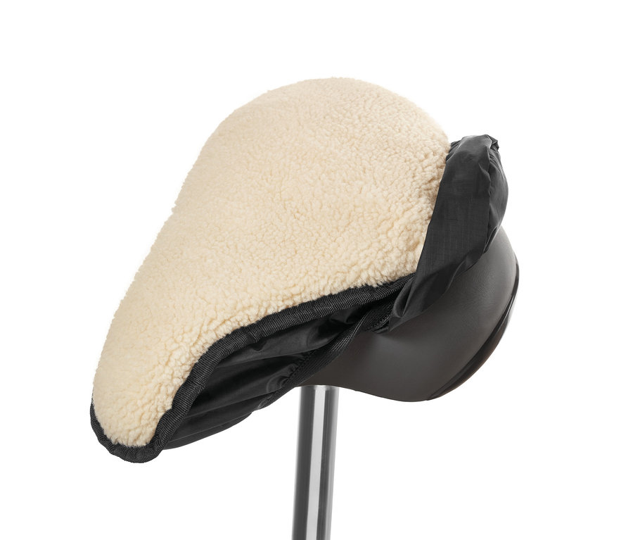 Egy 2 az 1-ben nyeregfedelet fényképeztek le közelről, bézs báránybőrrel és fekete nylon szegéllyel.