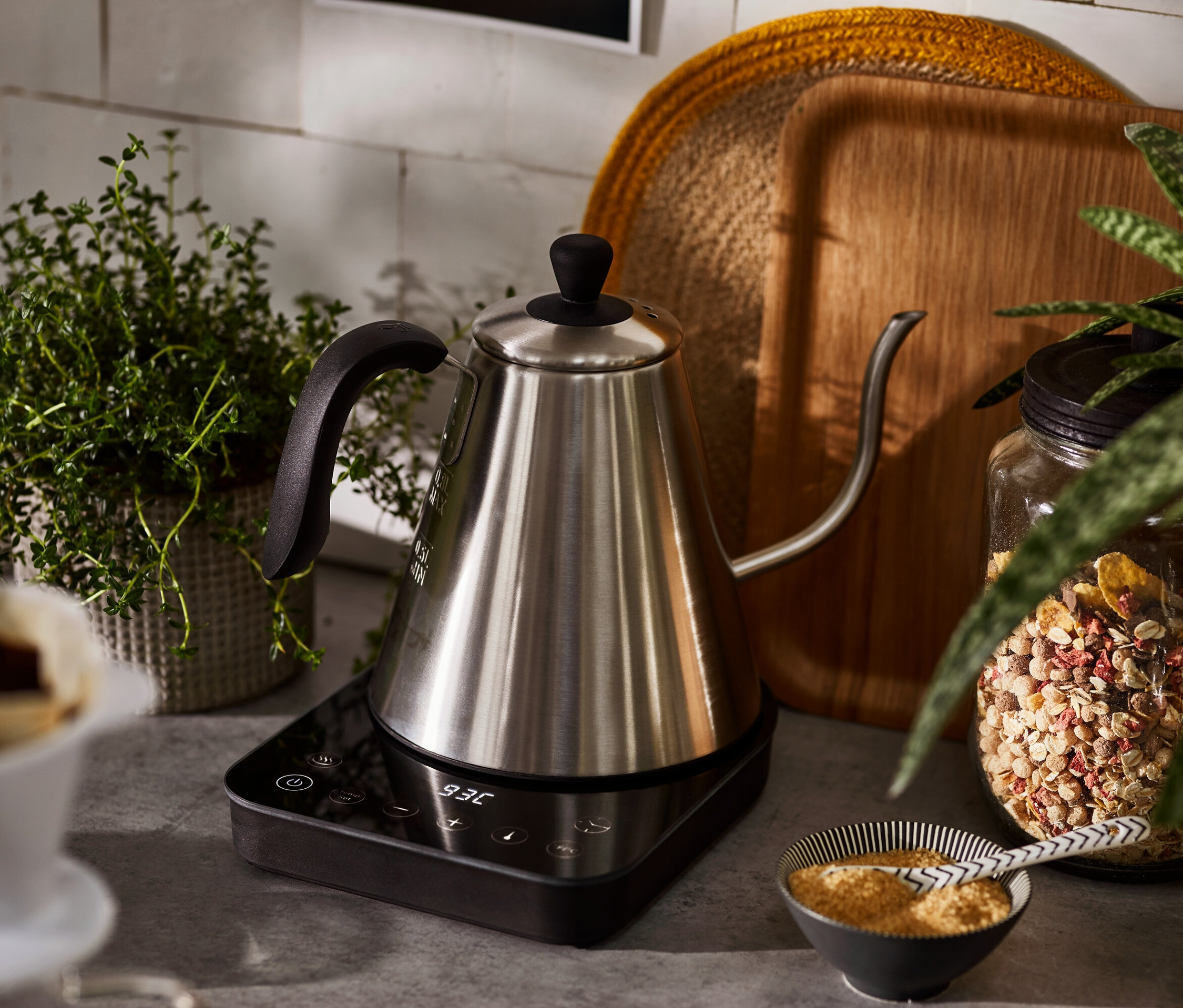 Egy elektromos hattyúnyakú vízforraló áll egy talapzaton.