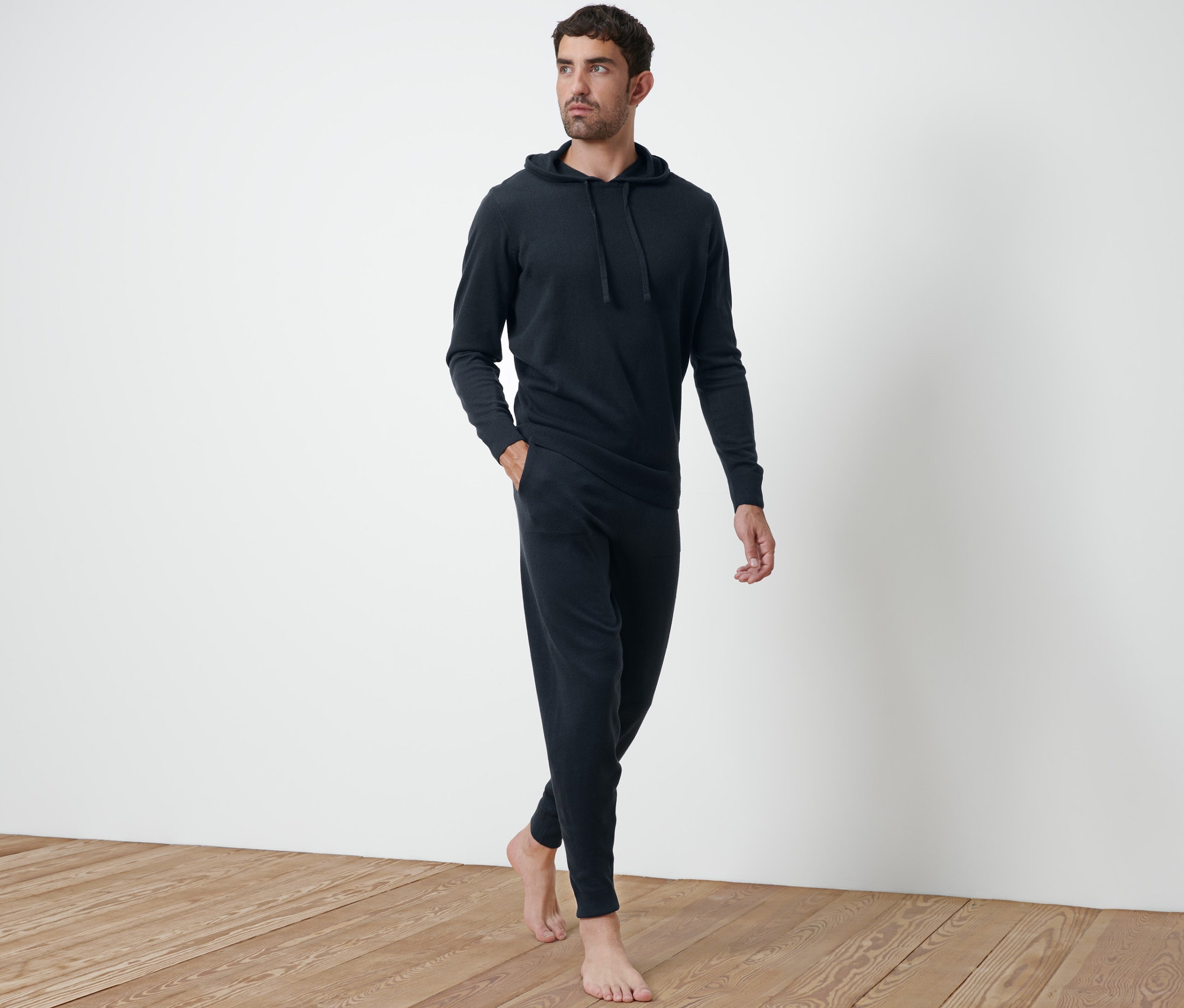 Férfi sétál, sötétkék kötött szabadidőnadrágot visel.