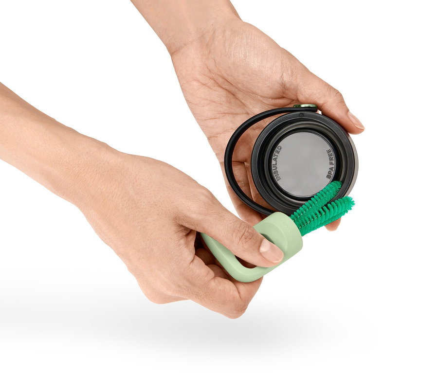 A kezek egy 3 az 1-ben pohár- és üvegmosó kefét tartanak, és egy fedelet tisztítanak.