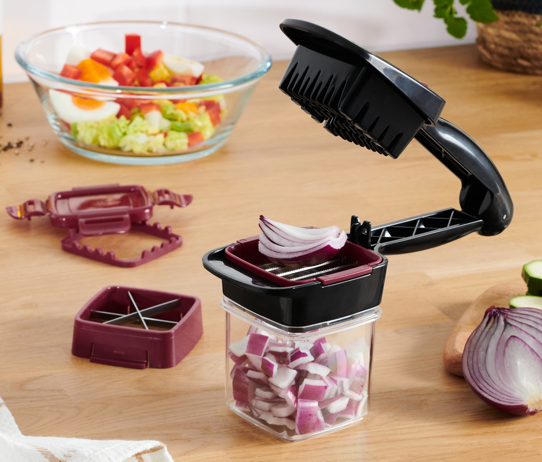 Egy vöröshagymát szeletelnek a Nicer Dicer Quick aprítóval.