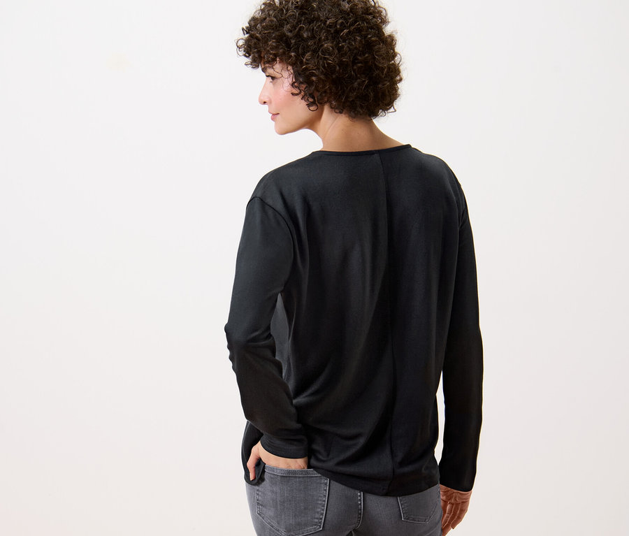 Hátulnézetű nő fekete pólóblúzt visel.