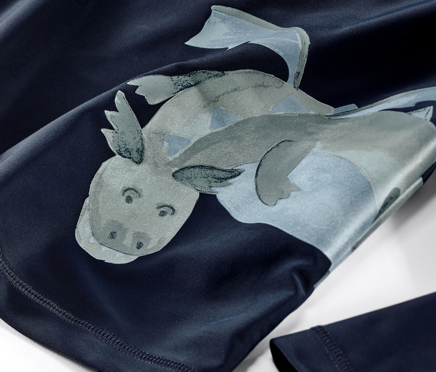 Egy kisgyerek UV-szűrős együttes közeli képe, sárkányos.