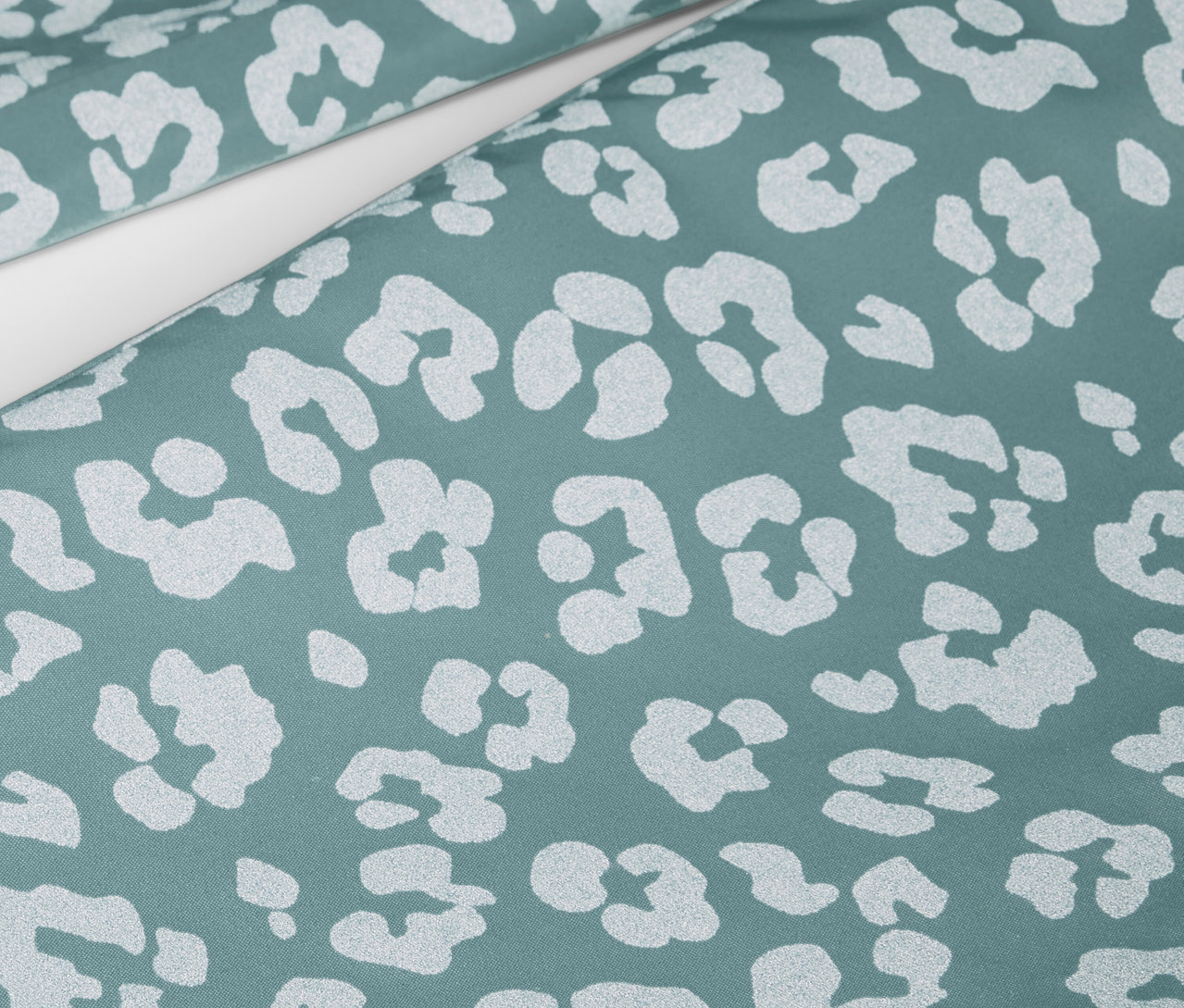 Közelkép egy gyermek esőnadrágról, fényvisszaverő elemekkel és állatmintával.