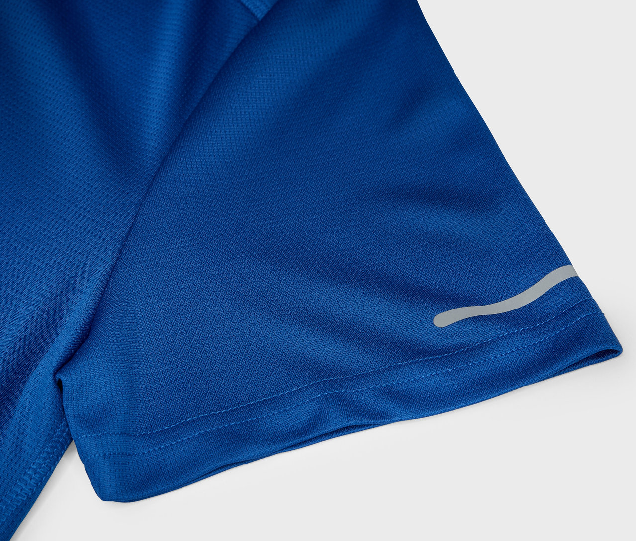 Egy kék, rövid ujjú sport póló részlete, fényvisszaverő csíkkal.