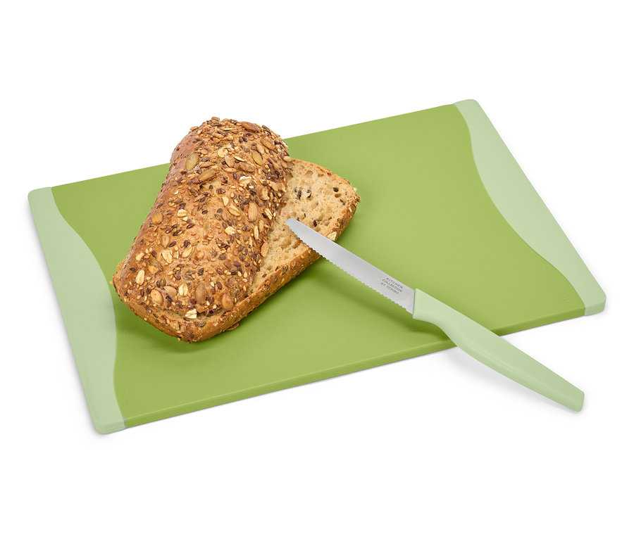 Kenyér és kés egy zöld vágódeszkán.