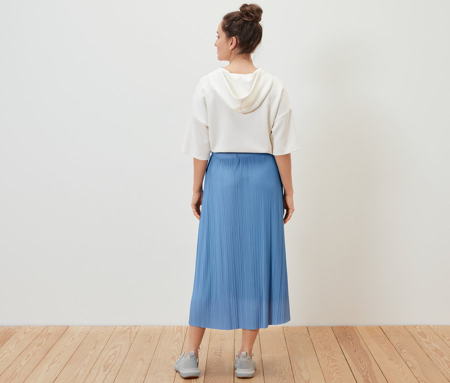 Nő visel egy pliszészoknyát.