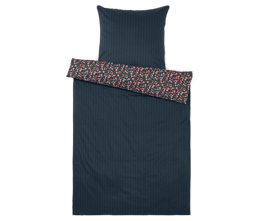 Kék ágynemű virágmintával a szegélyen.