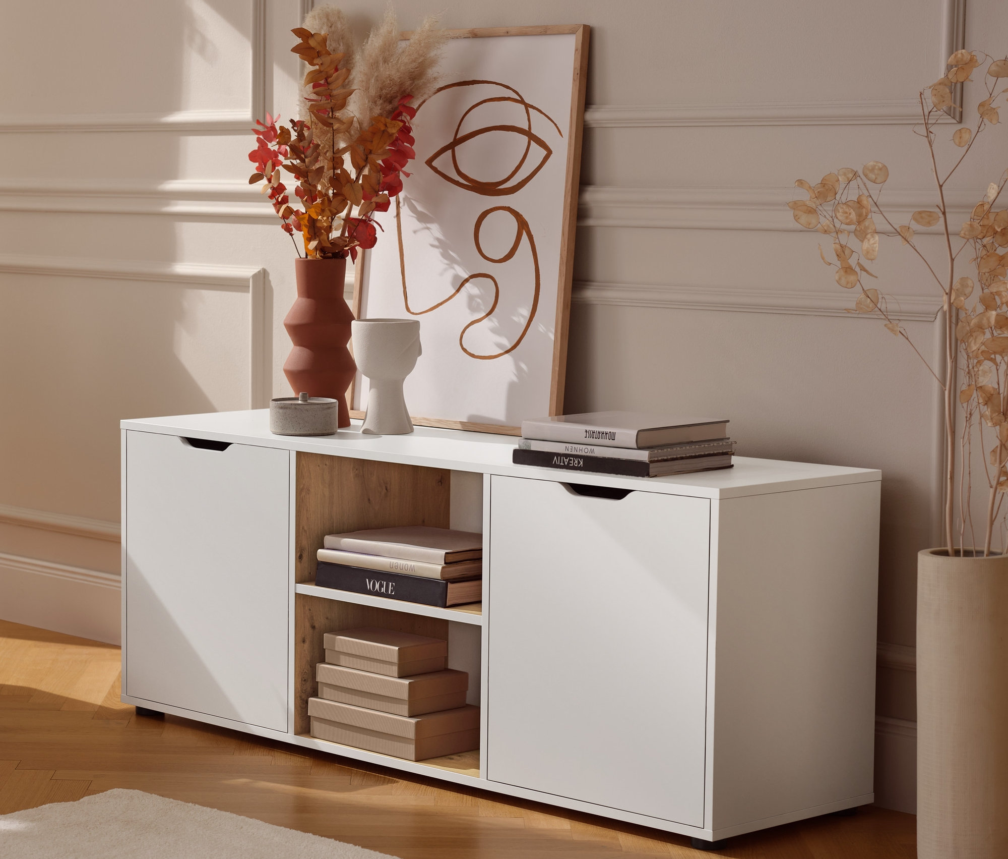 Fém dohányzóasztal egy komód mellett, fiókokkal.