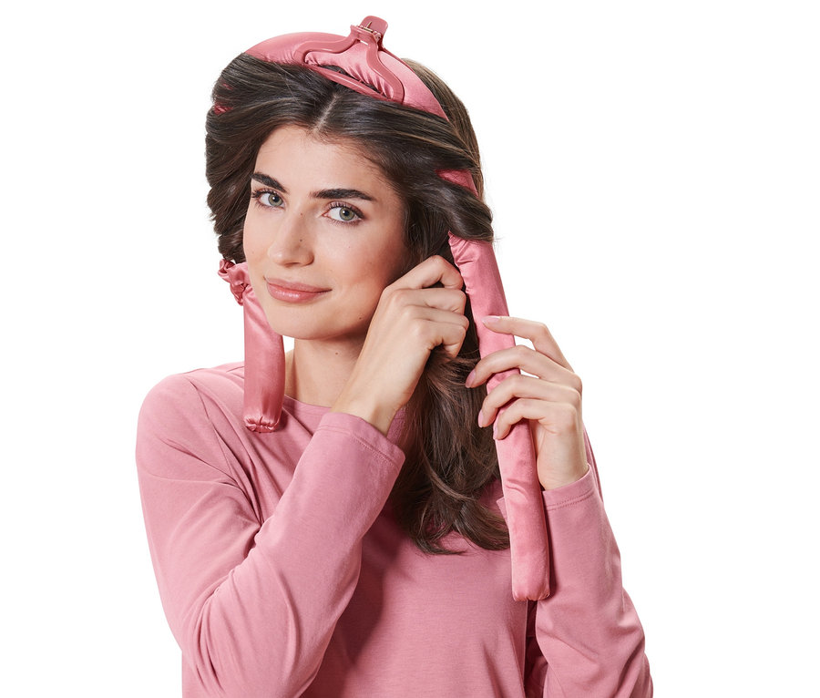 Nő hőmentes hajcsavarót használ a hajába.