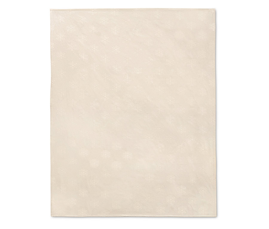 Egy krémszínű, hópehely mintás jacquard asztalterítő.