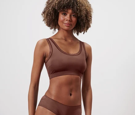 Nő visel gesztenyebarna bustier melltartót és alsóneműt.