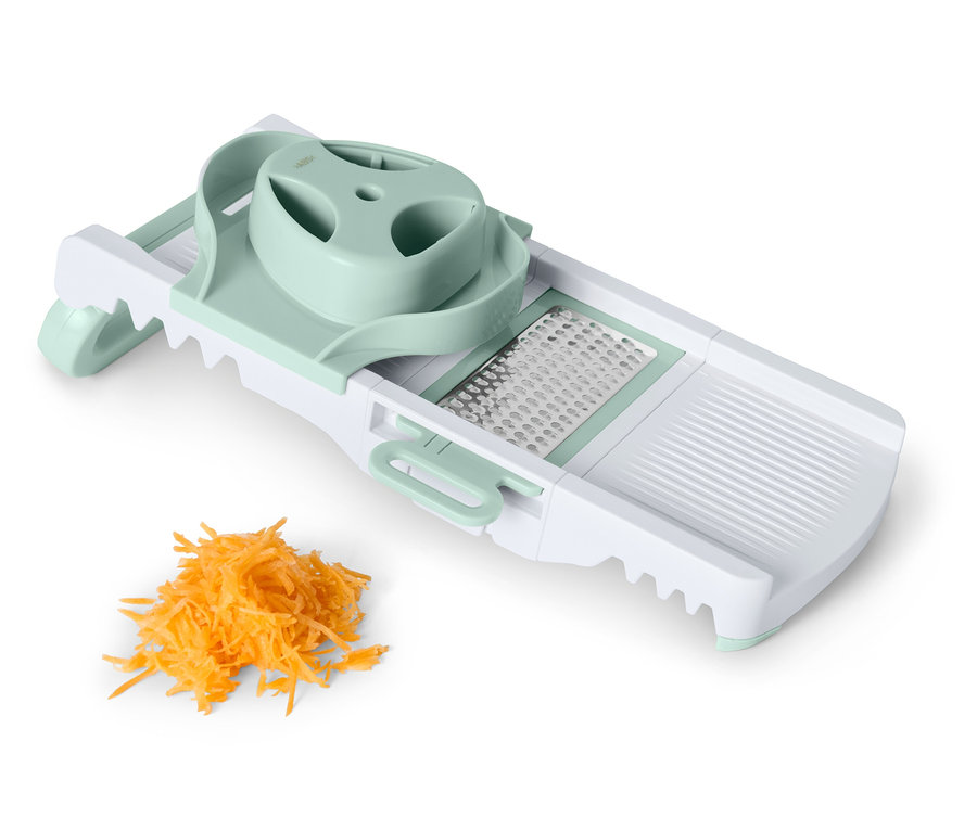 Zöldségszeletelő reszelt sárgarépa kupaccal.