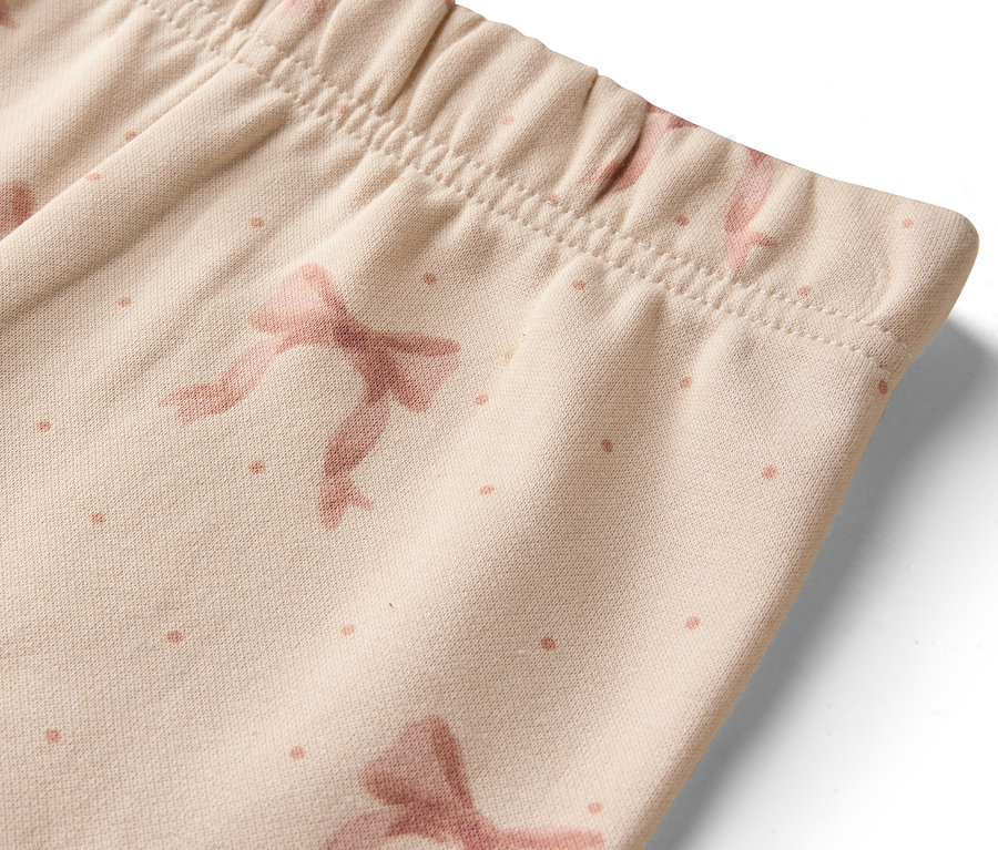 Egy bézs leggings részlete masnikkal és pöttyökkel.