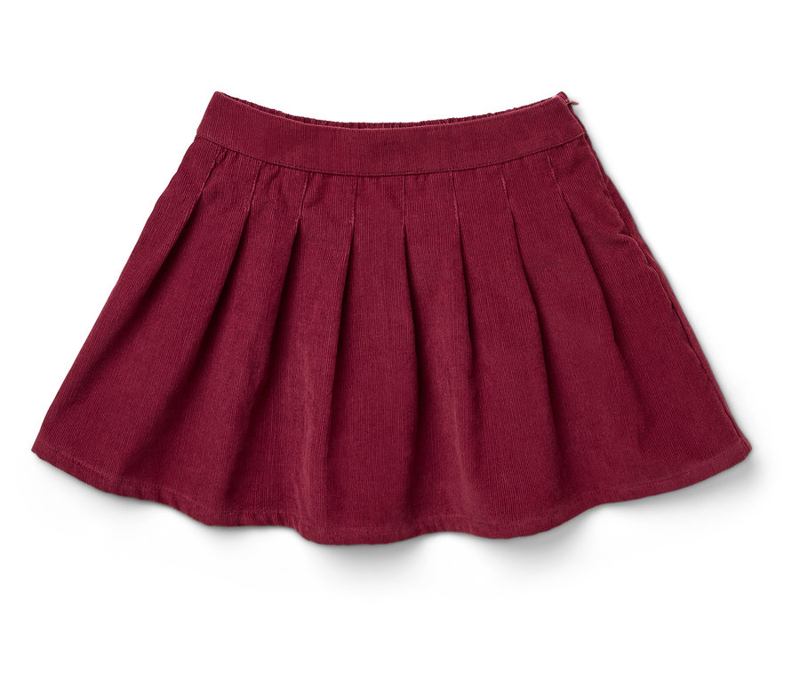 Egy bordó, pliszírozott kordbársony szoknya fekszik egy fehér háttéren.