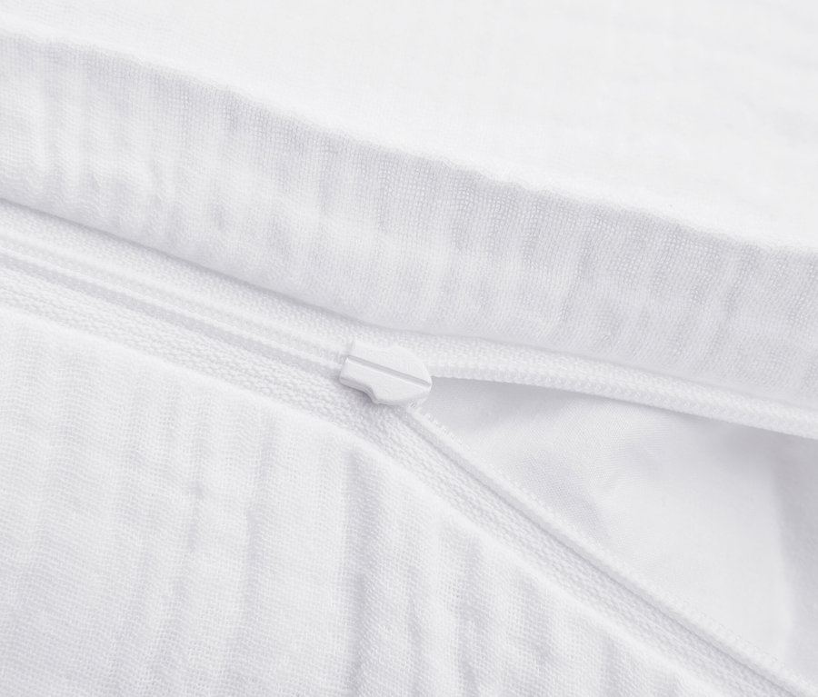 Egy fehér cipzáras ágynemű részlete.