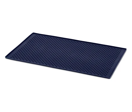 Kék, téglalap alakú, apró lyukakkal ellátott szőnyeg fehér háttéren.
