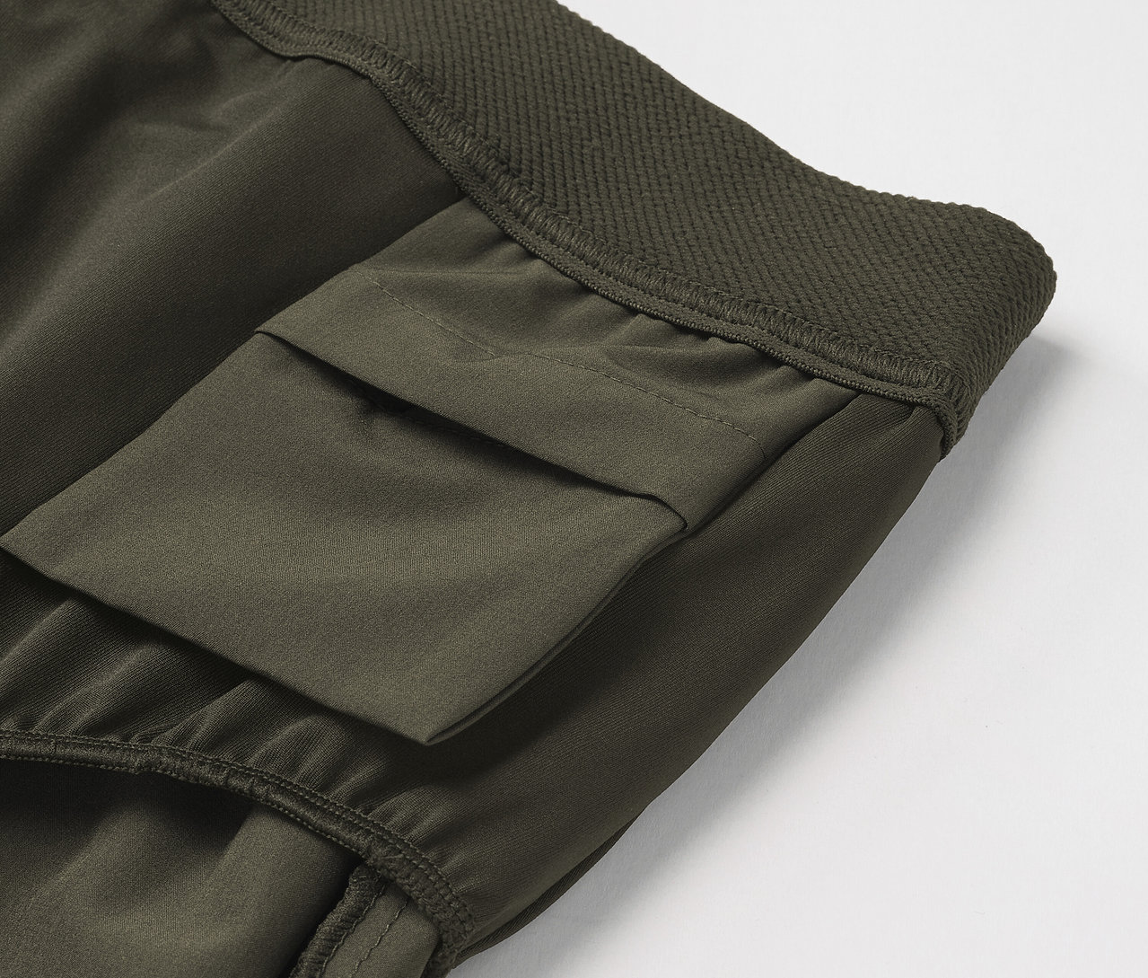 Egy olívazöld cargo nadrág részlete zsebbel.