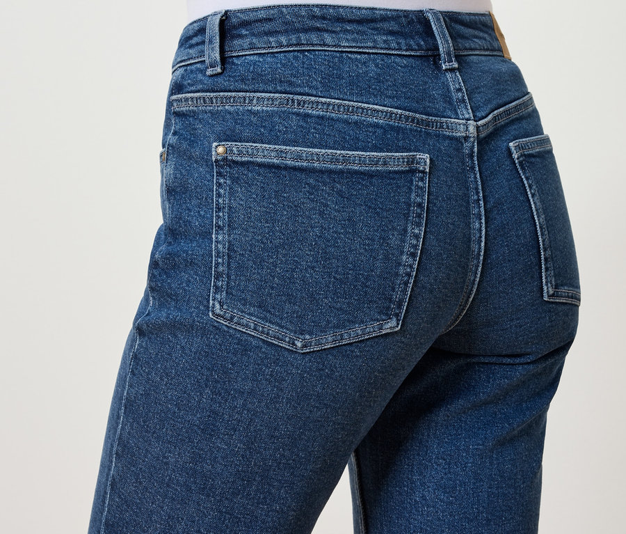 Kék farmernadrág hátsó részletének közeli képe zsebekkel.