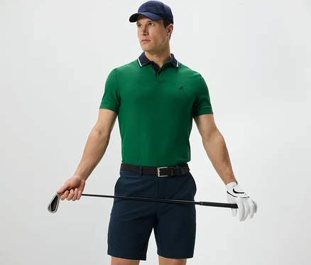 Férfi golfütőt tart, és zöld funkcionális pólót visel.