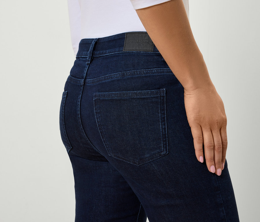 Egy nő testhezálló kék farmerjének hátsó részlete.