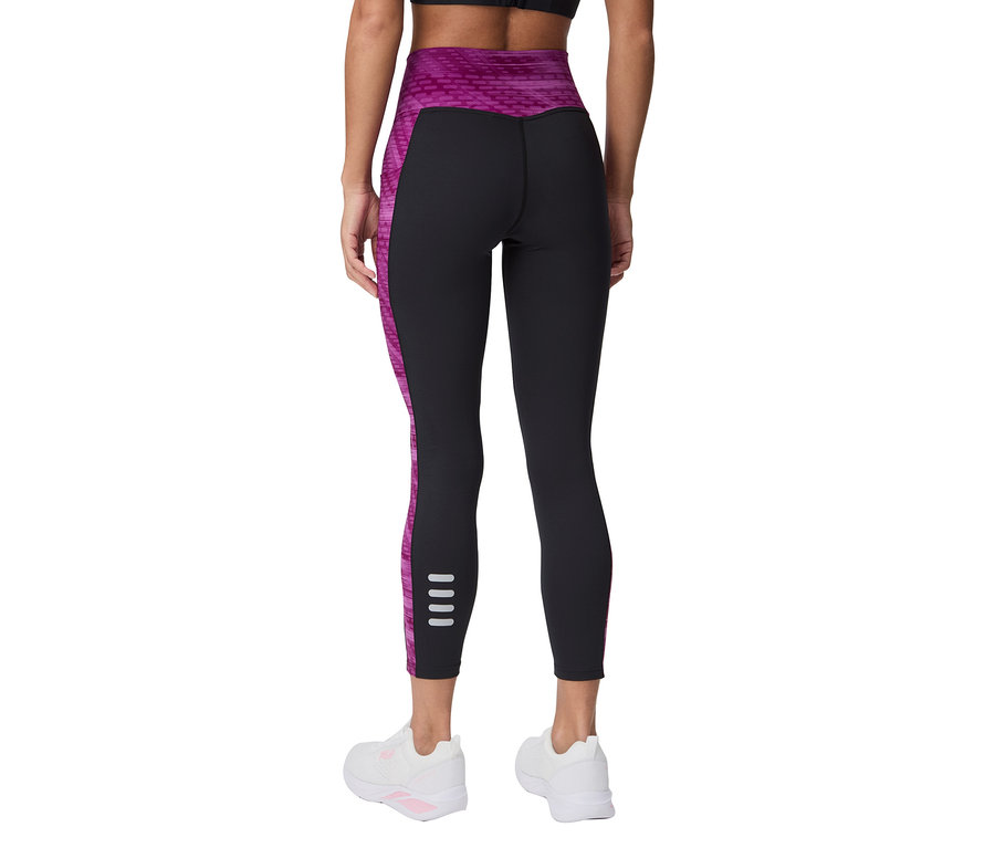 Hátulnézet egy fekete leggingset, rózsaszín díszítéseket és fehér sportcipőt viselő nőről.