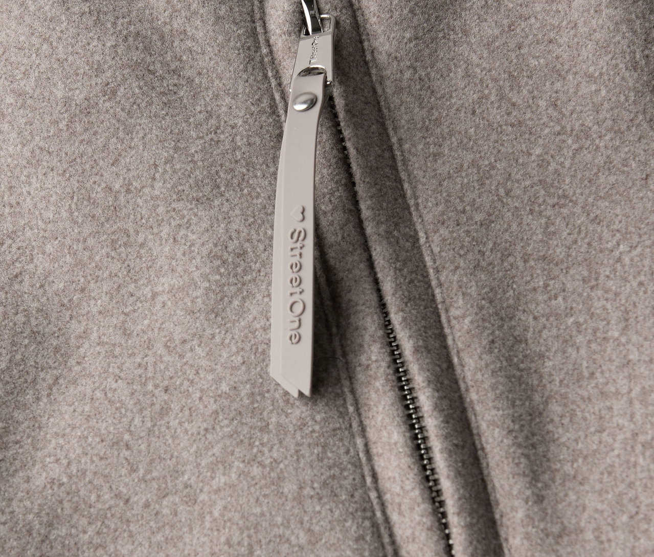 Közelkép egy Street One rövid kabátról, cipzárral és függővel.