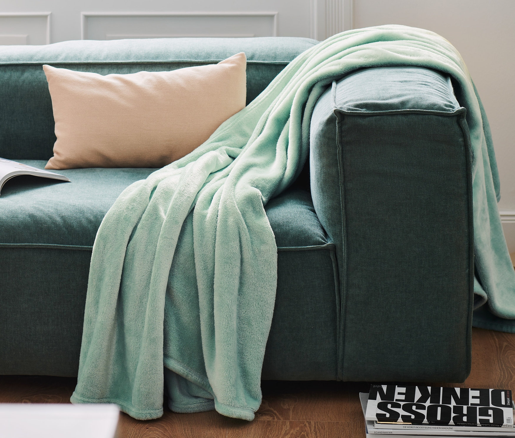 Egy puha takaró és egy párna van egy kanapén.